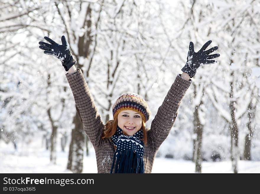 Beautiful young red-haired woman in winter park. Outdoor shot.