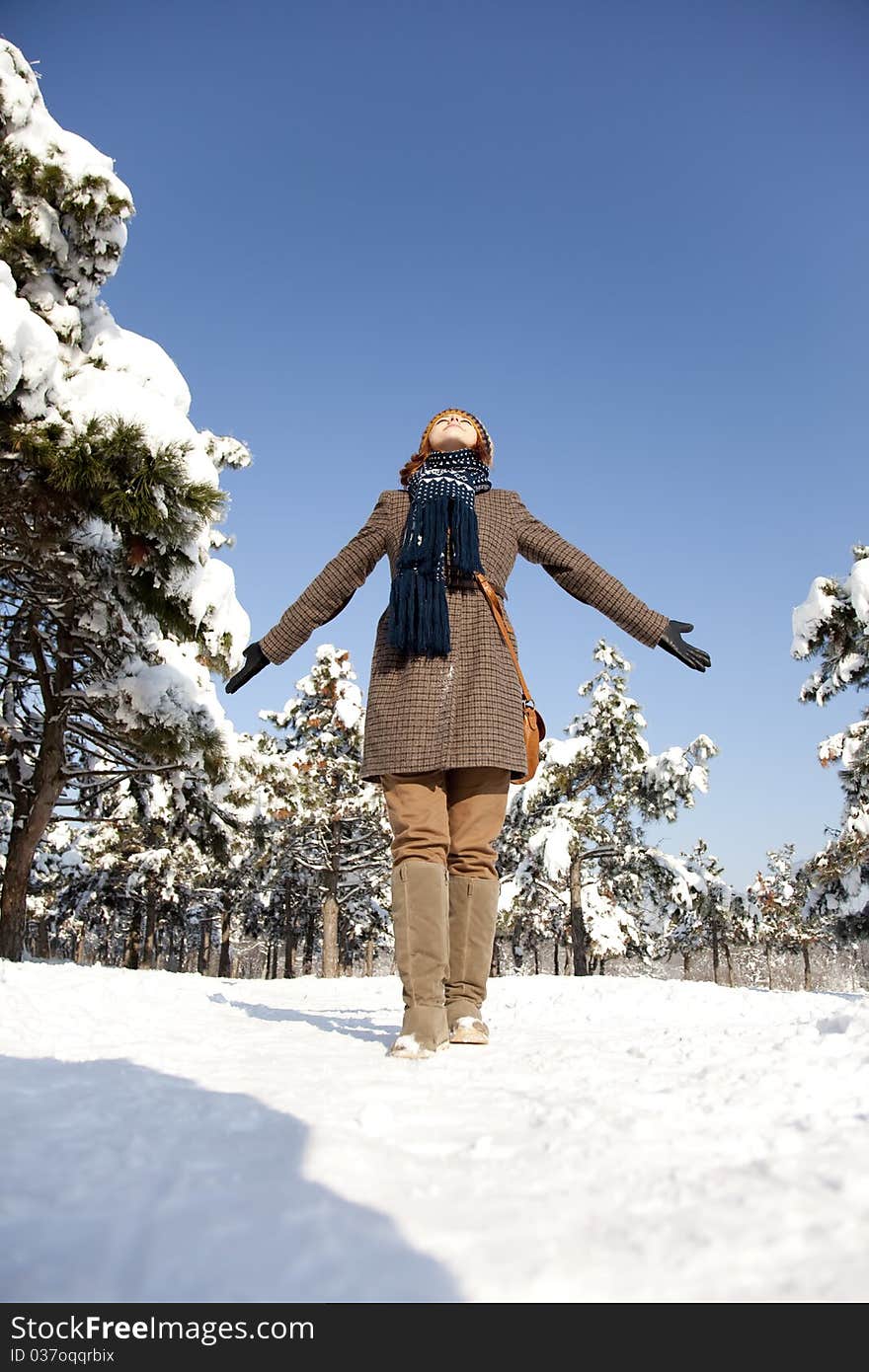 Beautiful young red-haired woman in winter park. Outdoor shot.