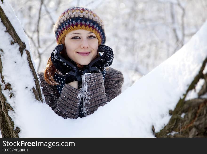 Beautiful young red-haired woman in winter park. Outdoor shot.