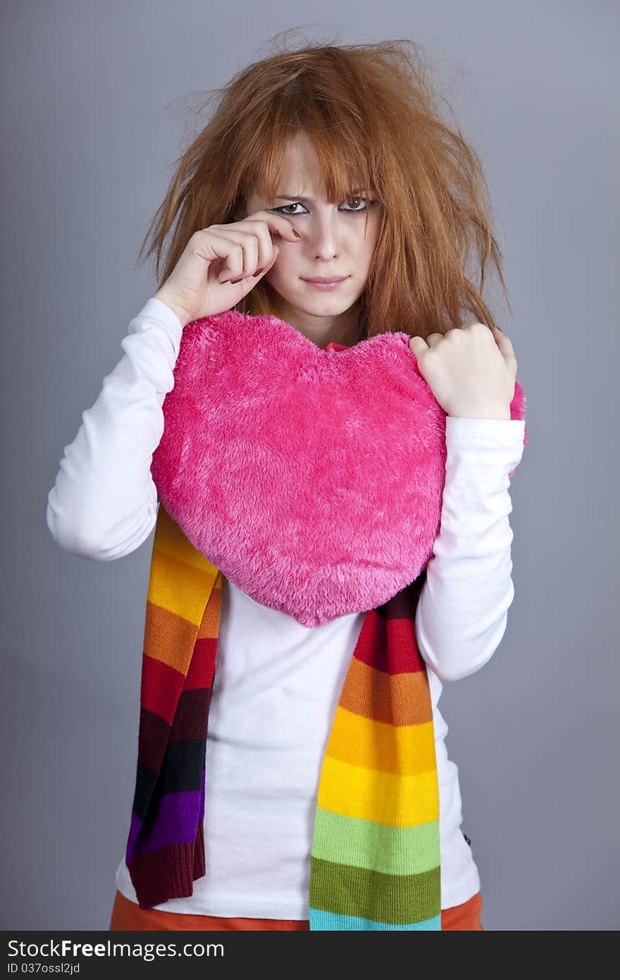 Sad girl with heart. St. Valentine Day. Studio shot.