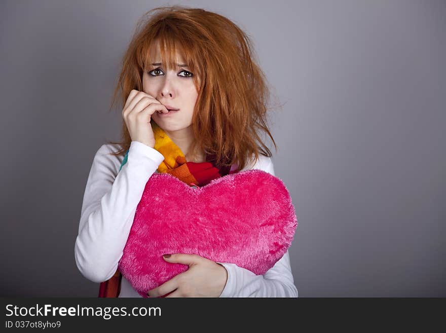 Sad girl with heart. St. Valentine Day. Studio shot.