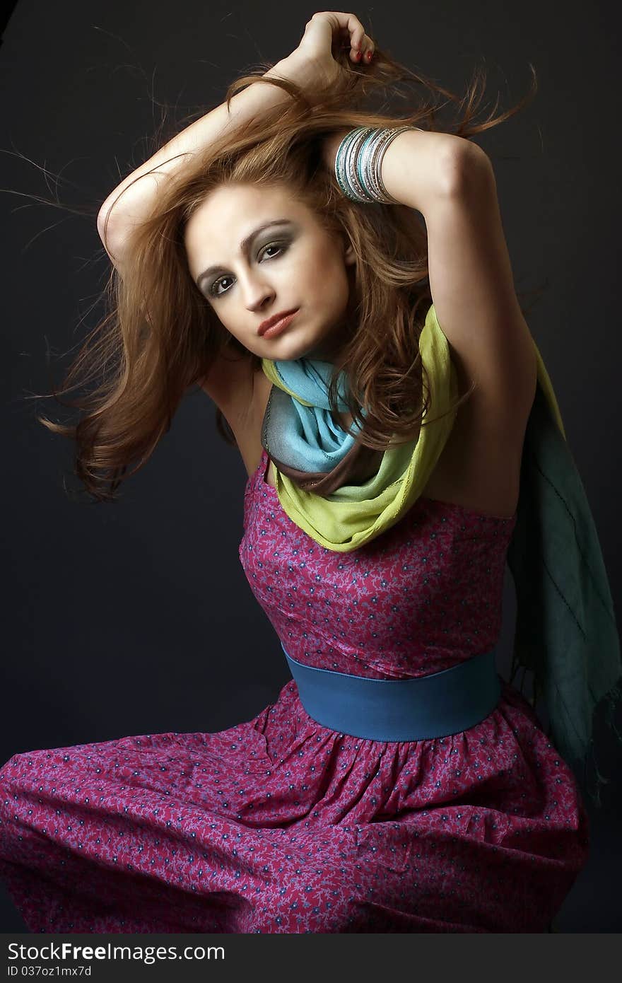 Sensual woman, with a hippie dress an multicolor scarf, playing with her hair, studio shot