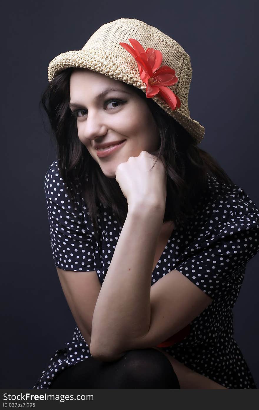 Pretty thoughtful lady with hat and a red flower in her hat, studio portrait. Pretty thoughtful lady with hat and a red flower in her hat, studio portrait