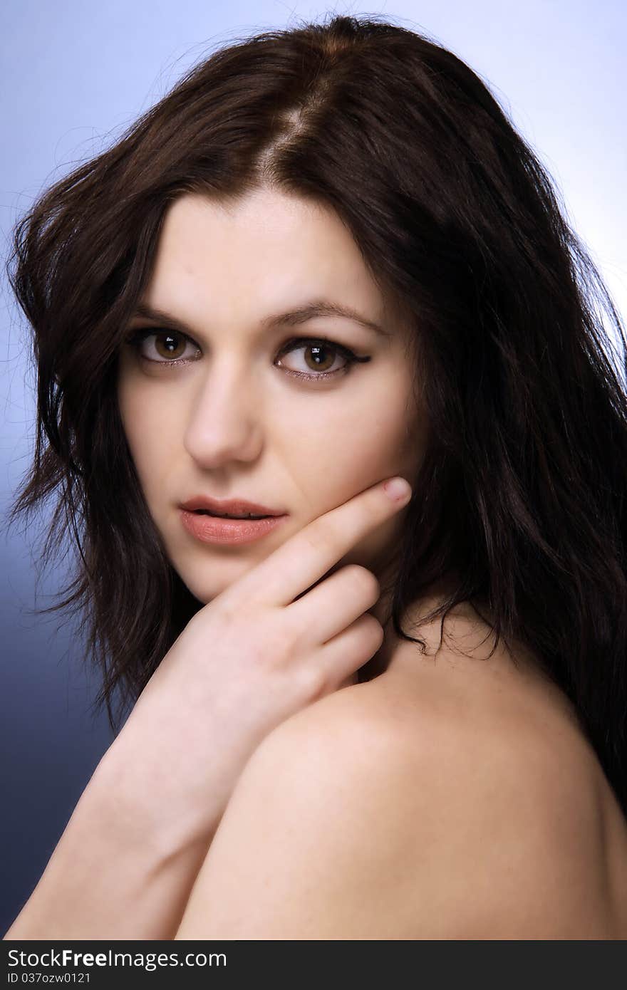 Sensual brunette looking at the camera, head and shoulders studio shot