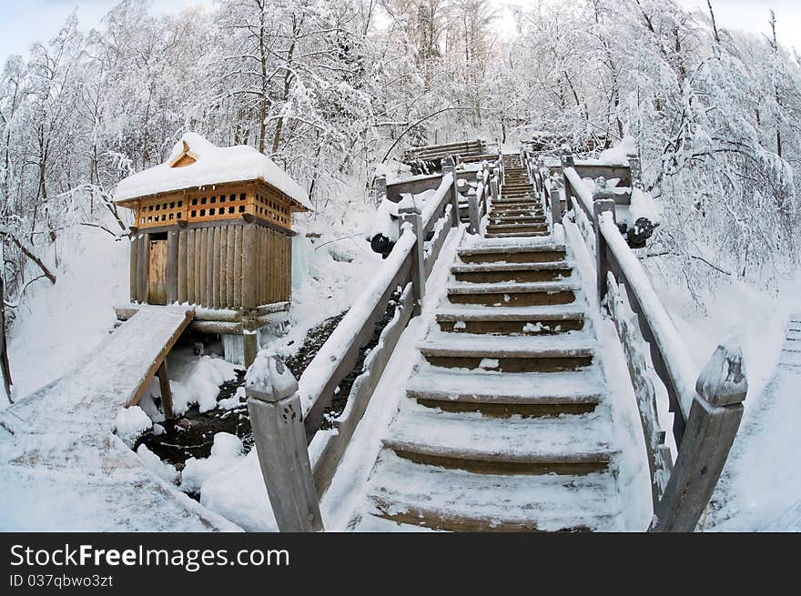 Snow-covered wooden ladder and booth for bathing against winter wood. Snow-covered wooden ladder and booth for bathing against winter wood