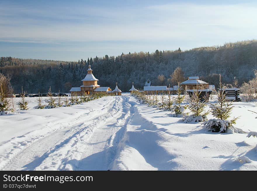 Snow-covered wooden church against winter wood. Snow-covered wooden church against winter wood