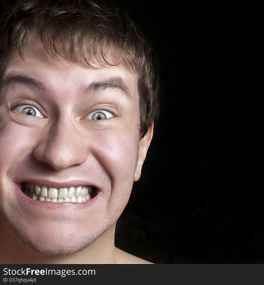 Portrait of a crazy or surprised guy close up. Isolated on a black background. Portrait of a crazy or surprised guy close up. Isolated on a black background