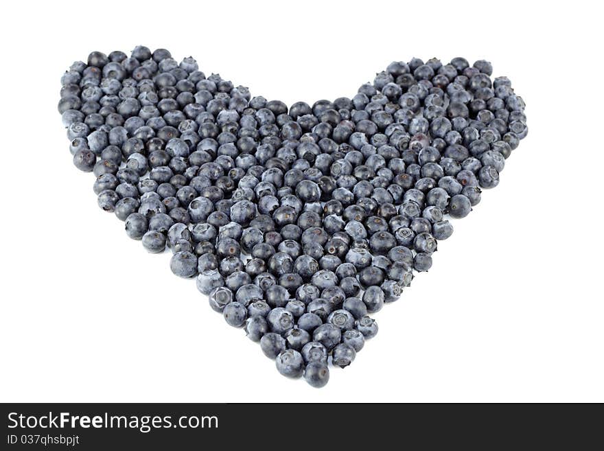 Natural blue purple fruit berry in the shape of large love on a white paper. Natural blue purple fruit berry in the shape of large love on a white paper.