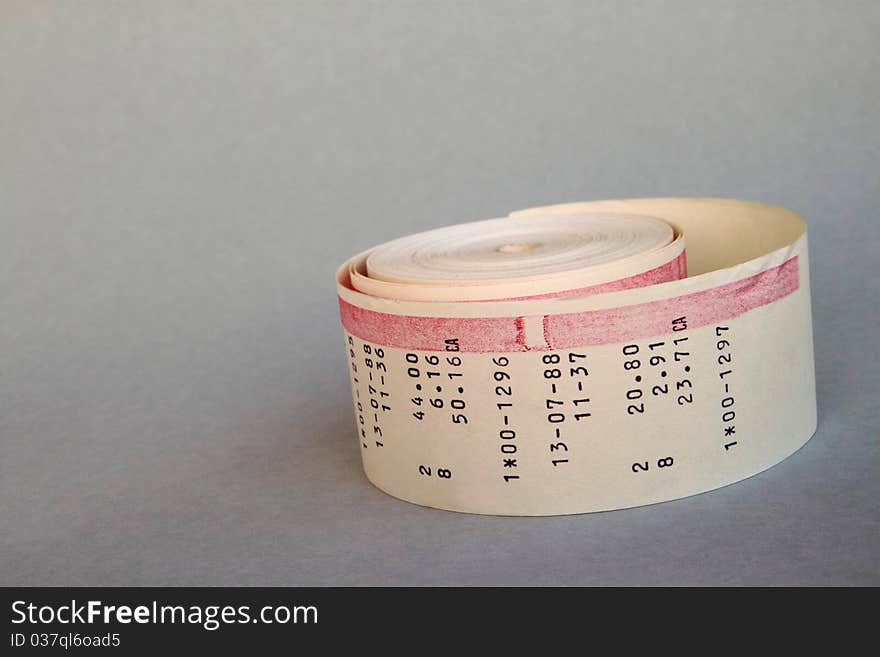 Desktop calculator paper roll on a grey background