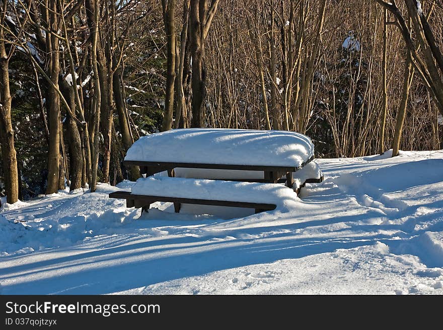 A soft blanket of snow covers up a pic-nic table. A soft blanket of snow covers up a pic-nic table