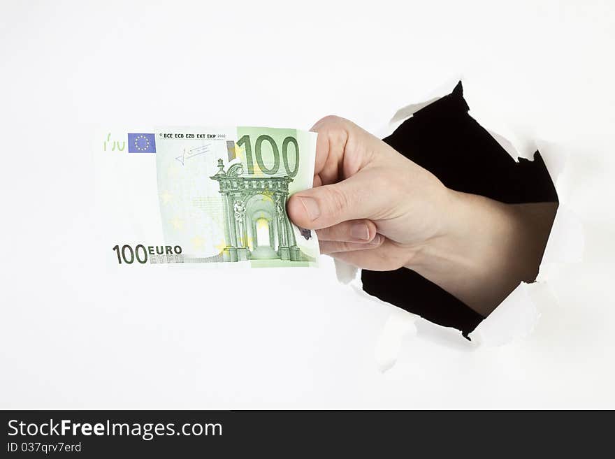 A men's hand breaks through a hole and shows a 100Euro banknote. A men's hand breaks through a hole and shows a 100Euro banknote