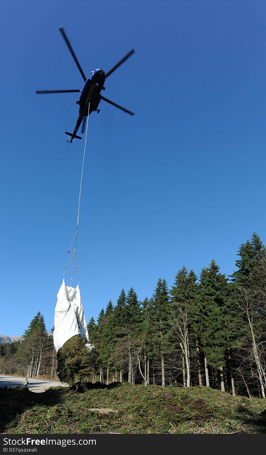 Helicopter with load. Branchers from mountain.