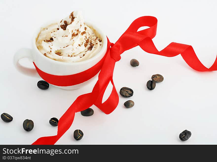 Cup of coffee with cream and red bow