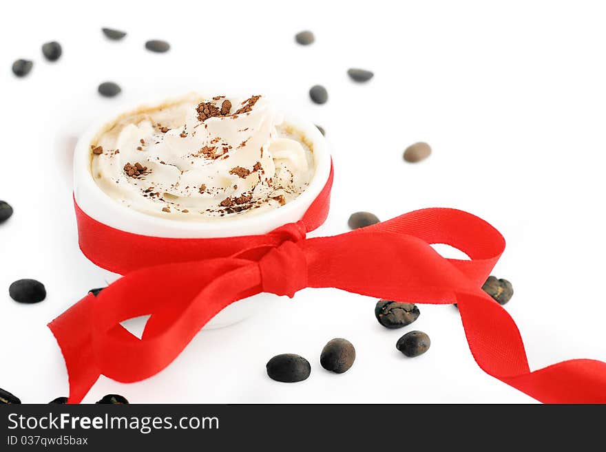 Cup of coffee with cream and red bow