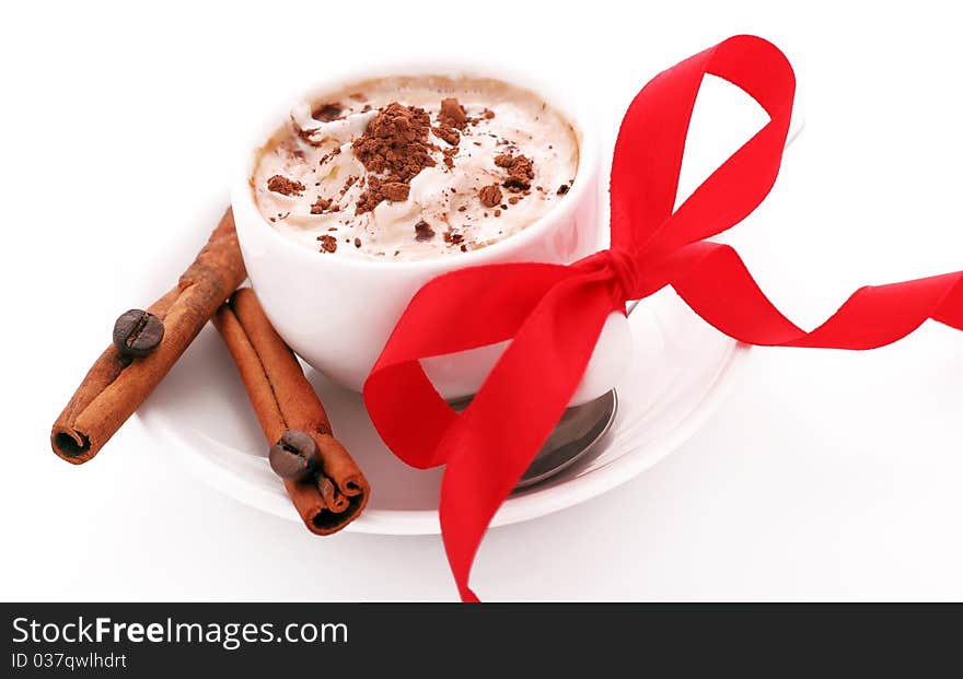 Cup of coffee with cream, cinnamon and red bow