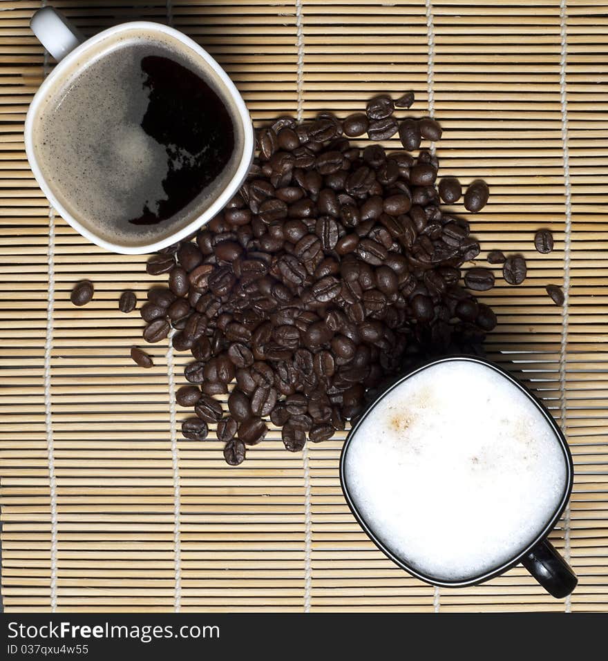 Two coffee cups and coffee beans