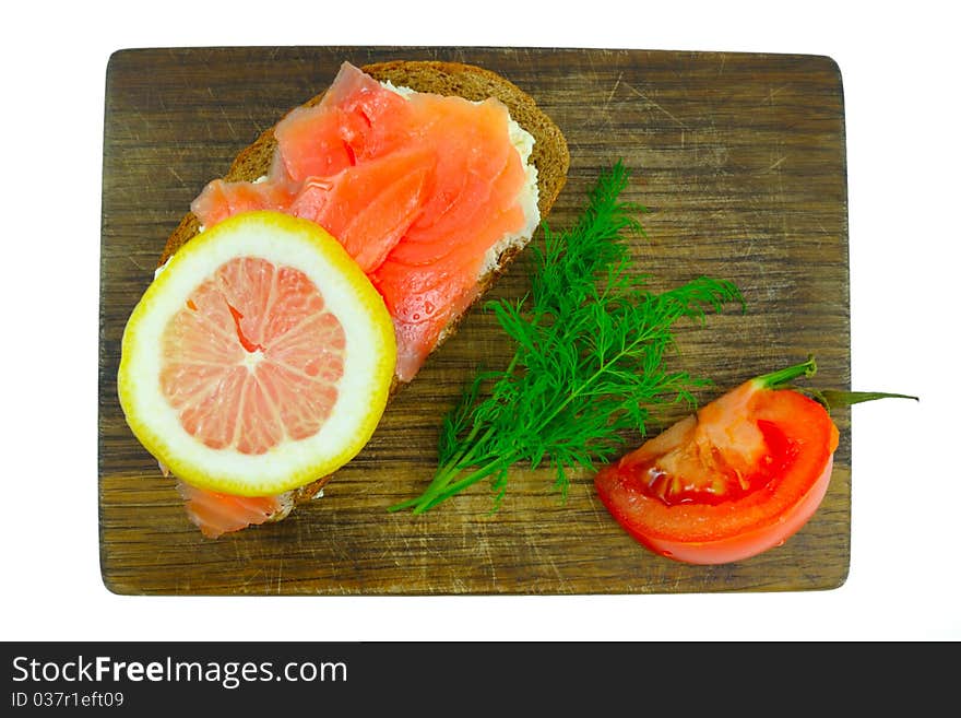 Smoked salmon, lemon and tomato on the board. Smoked salmon, lemon and tomato on the board