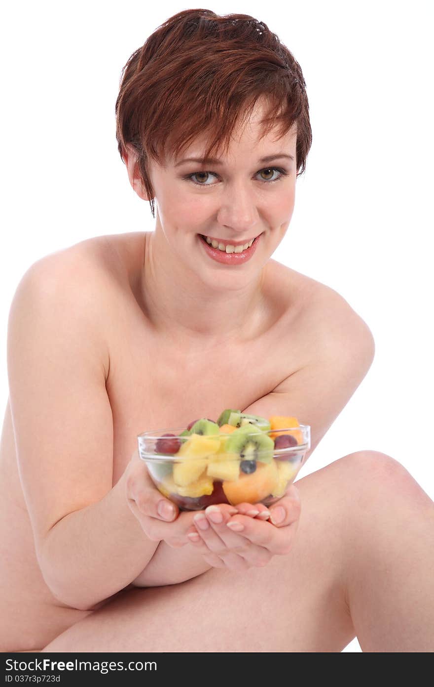 Beautiful healthy naked girl holding bowl of fruit