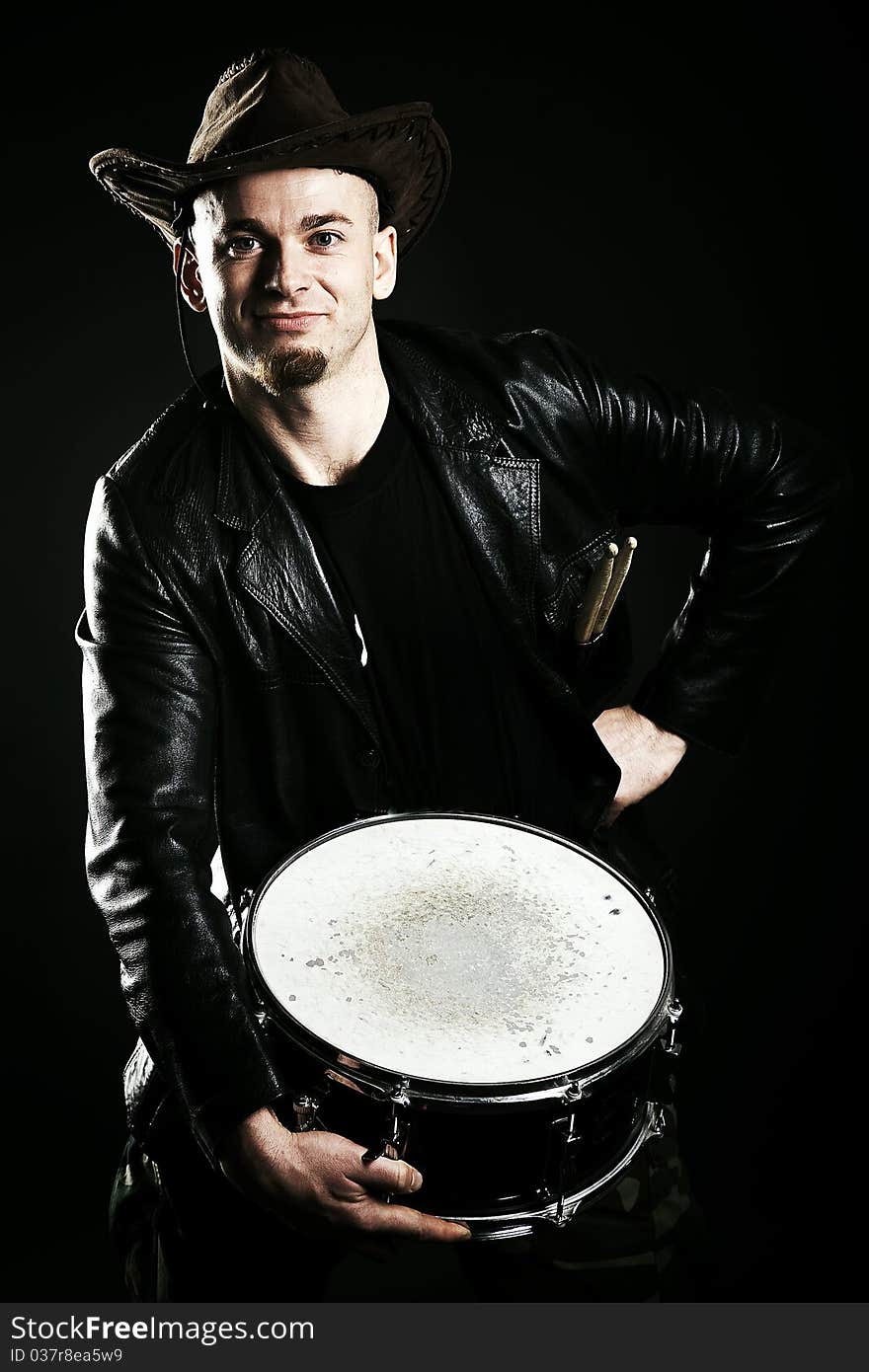 Portrait of a drummer in black background