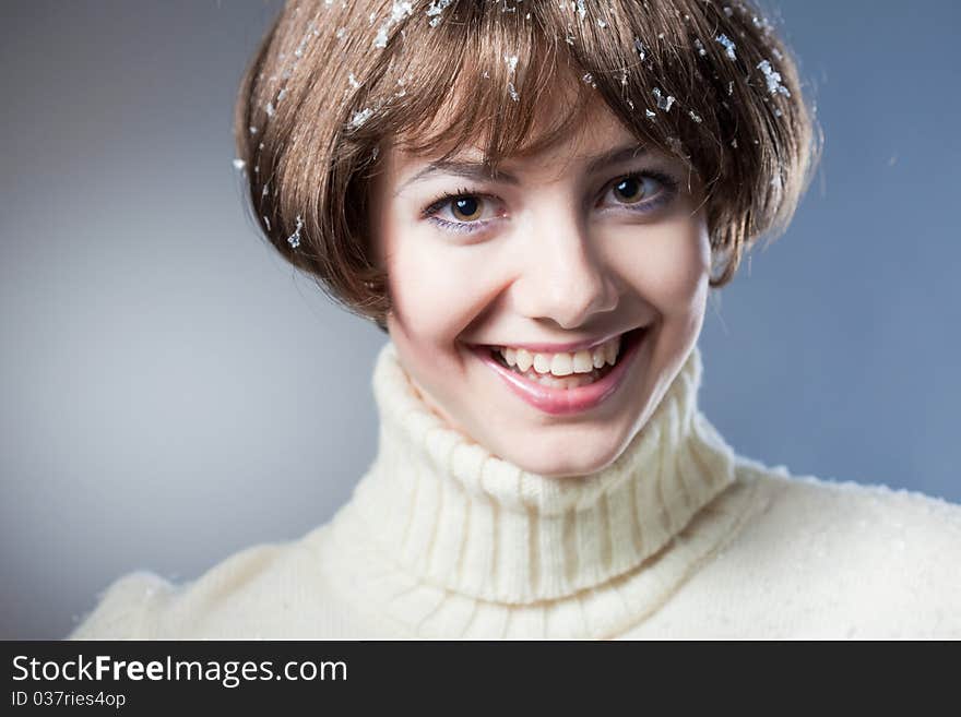 Young beautiful girl rejoices to snow, On a dark blue background