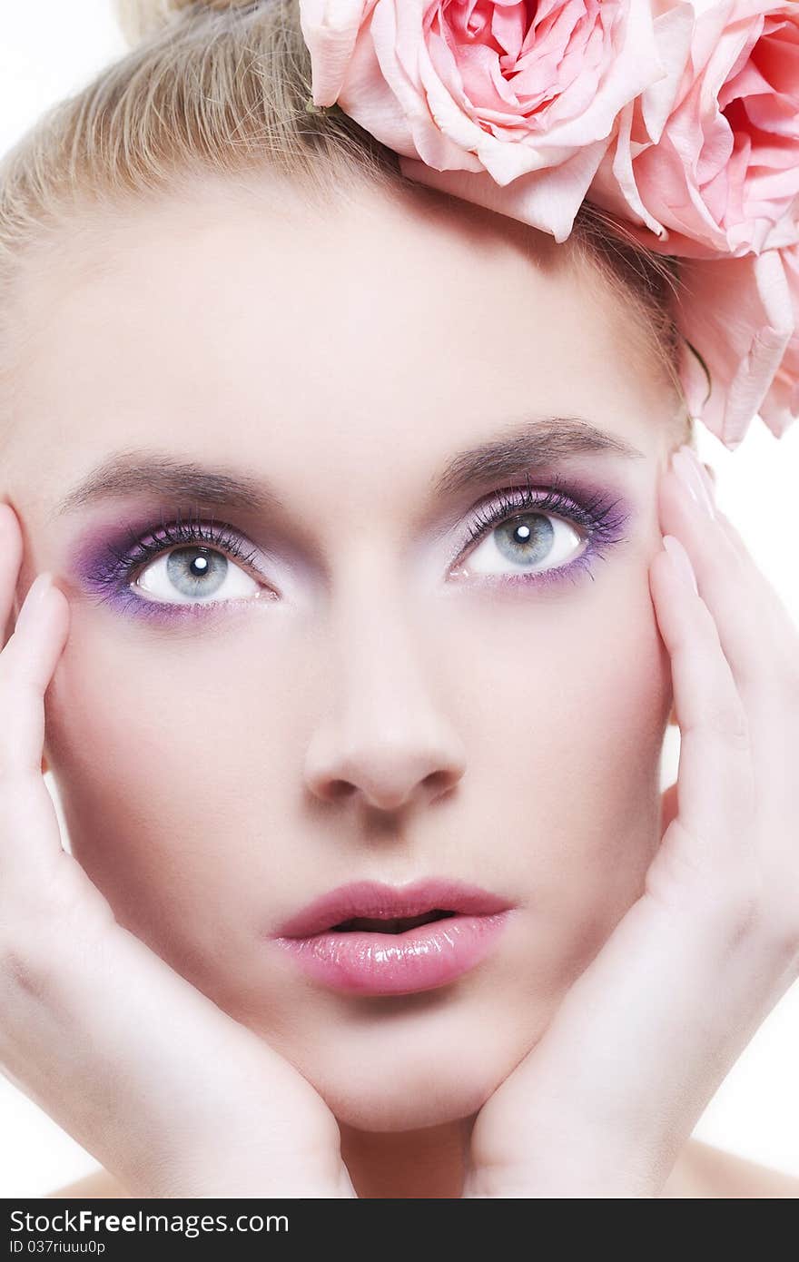 Portrait of young beautiful woman with roses in hair, on white background