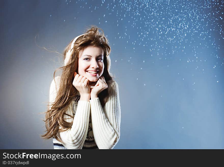 Young beautiful girl rejoices to snow, On a dark blue background