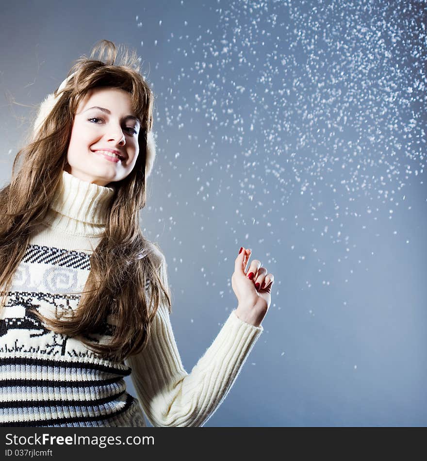 Young beautiful girl rejoices to snow, On a dark blue background