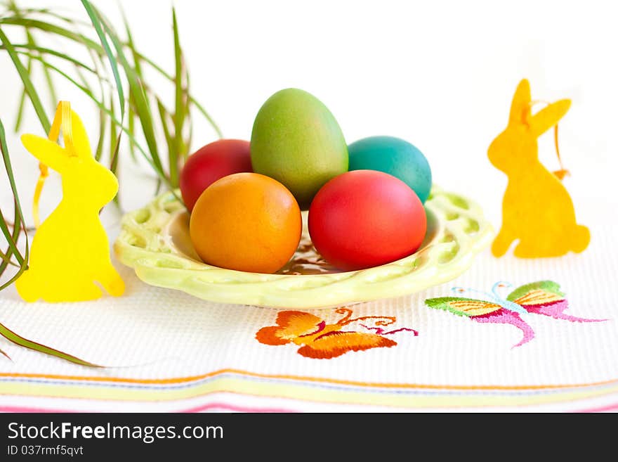 Easter eggs on a plate with rabbit decoration. Easter eggs on a plate with rabbit decoration