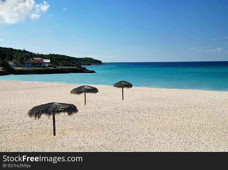 Beautiful white Cuban beach with parasols and turquoise sea. Beautiful white Cuban beach with parasols and turquoise sea