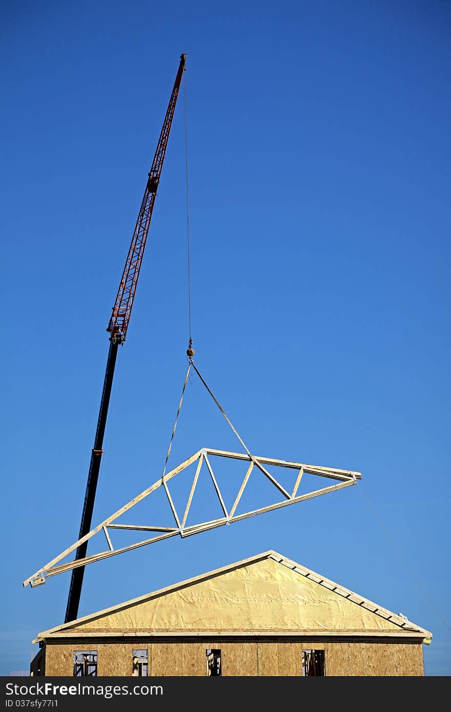 Crane lifting a roof onto a townhome. Crane lifting a roof onto a townhome