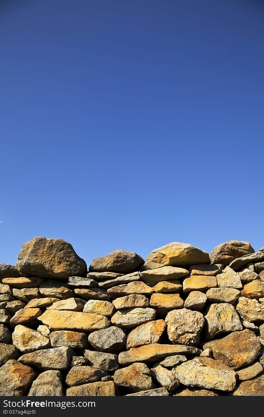 Rock wall shot against bright blue sky. Rock wall shot against bright blue sky