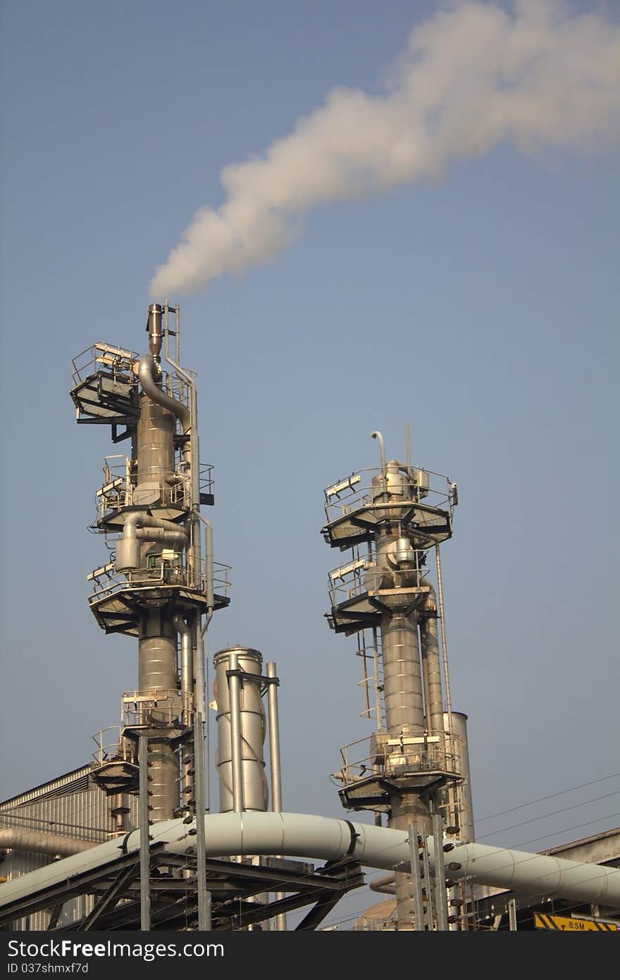 This is a modern industrial plant showing some chimneys emitting steam. This is a modern industrial plant showing some chimneys emitting steam.