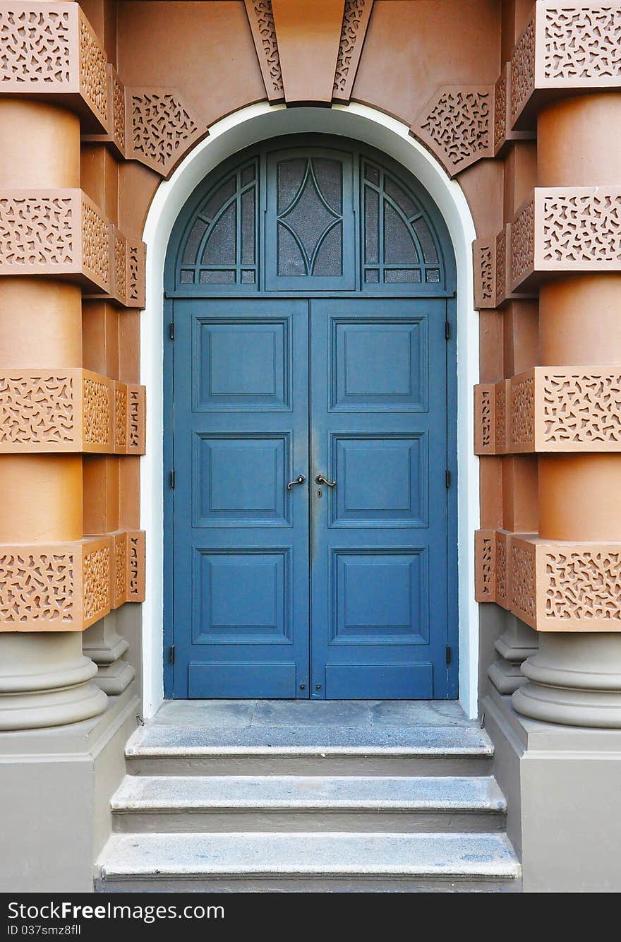Blue door on brown wall with giant column