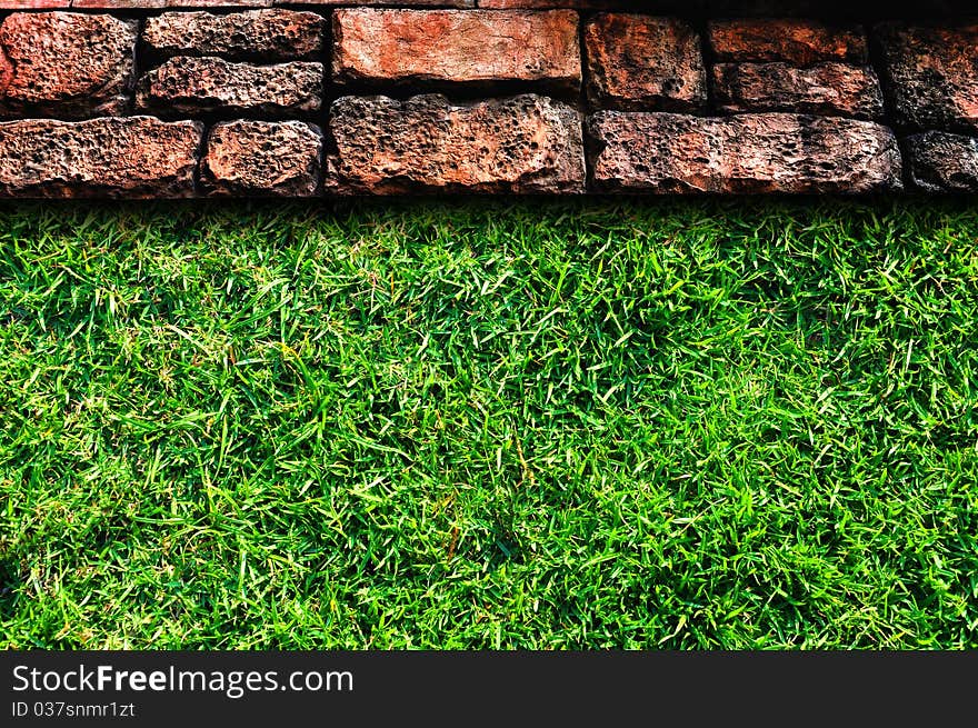 Old stone pavement and green grass field. Old stone pavement and green grass field