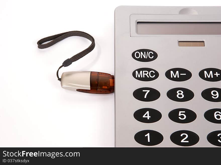 A large calculator with USB flash drive on white background