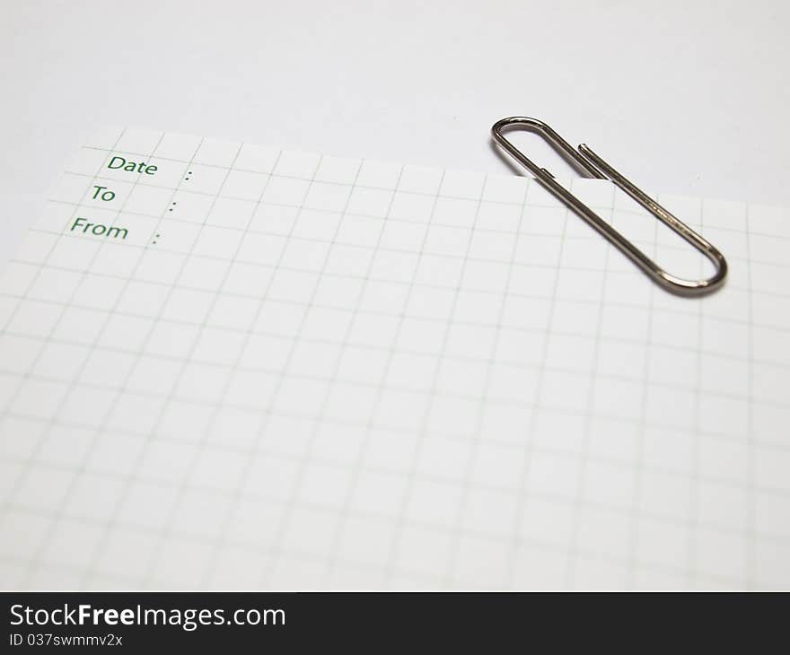 White paper note with table and metal clip