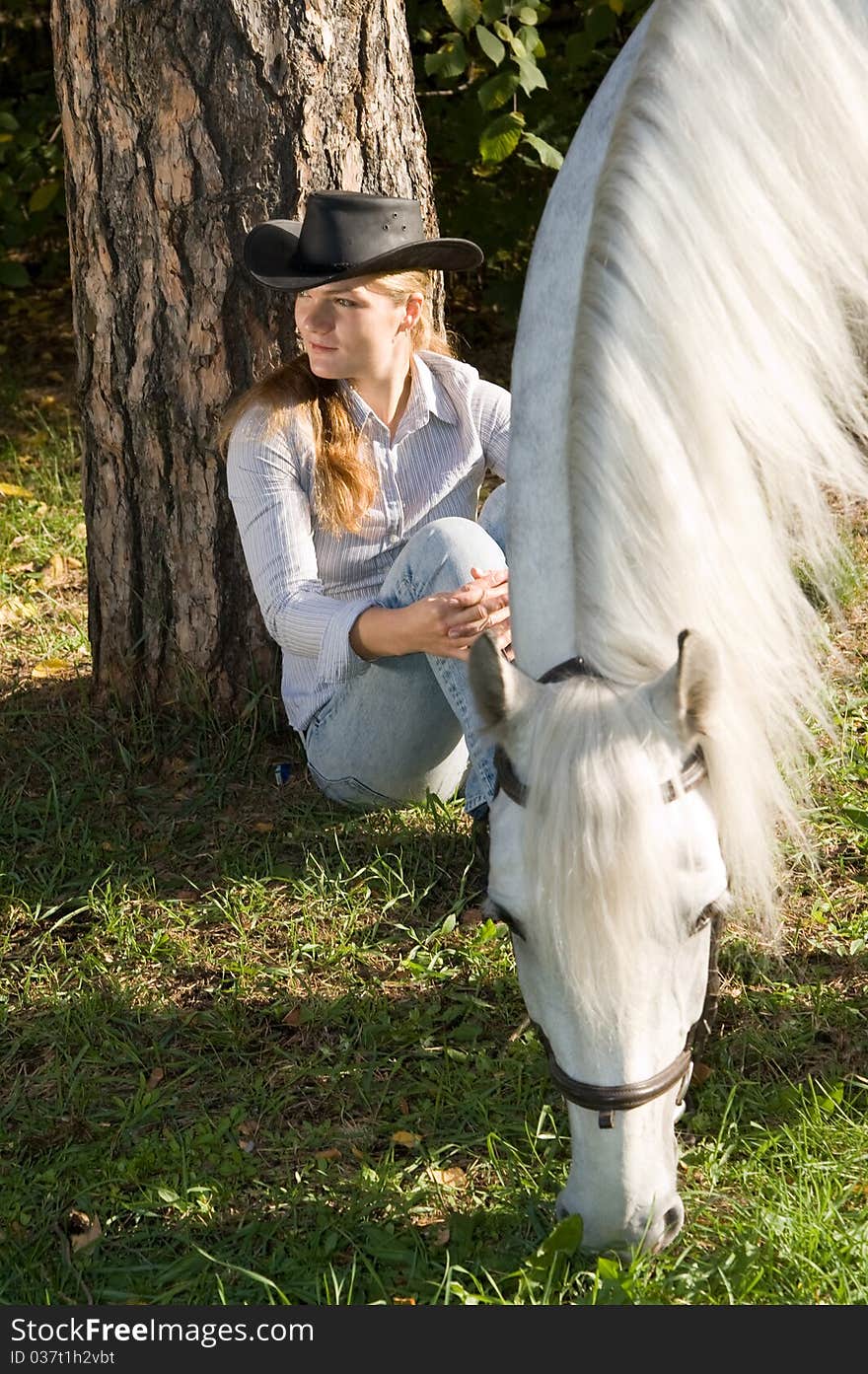 Portrait of young woman with her white horse on a green grass. Portrait of young woman with her white horse on a green grass