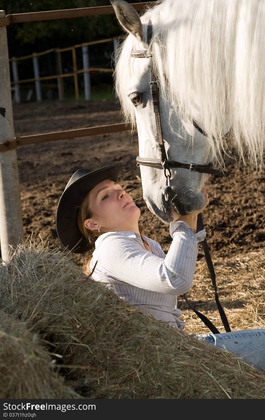 Portrait of young woman with her white horse on the farm yard. Portrait of young woman with her white horse on the farm yard