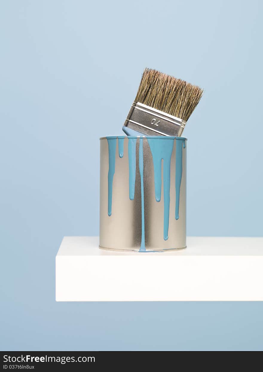 Paintcan and brush on blue background