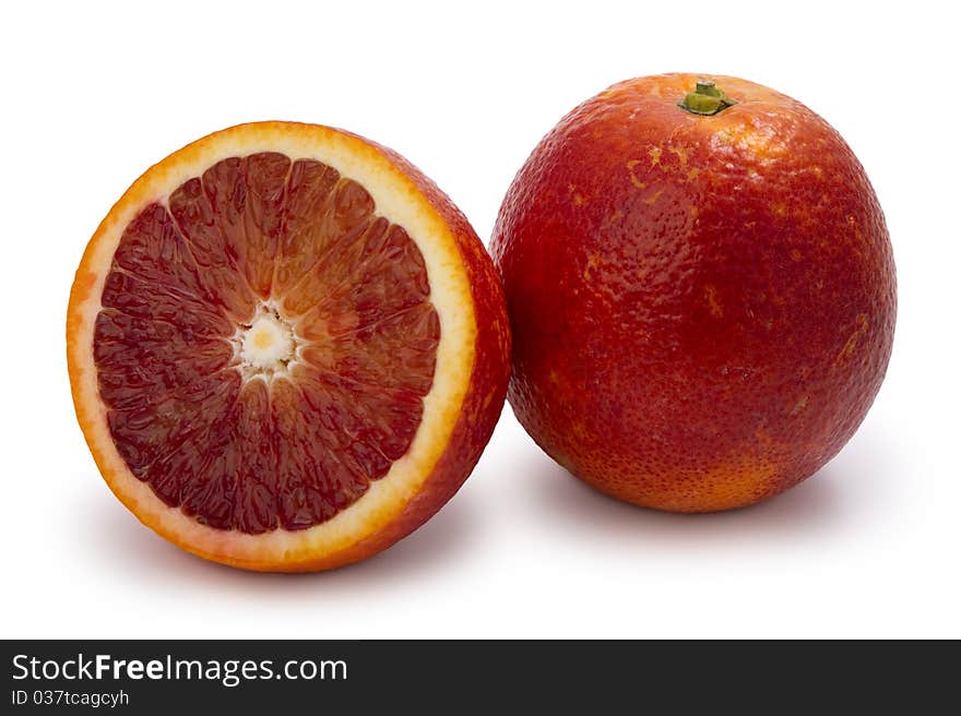 Red moroccan oranges, whole and half, isolated on white.