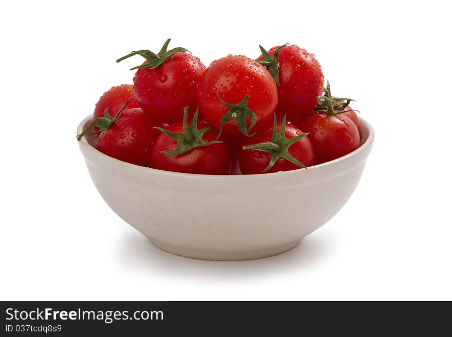 Ripe cherry tomatoes on a plate, isolated on white.