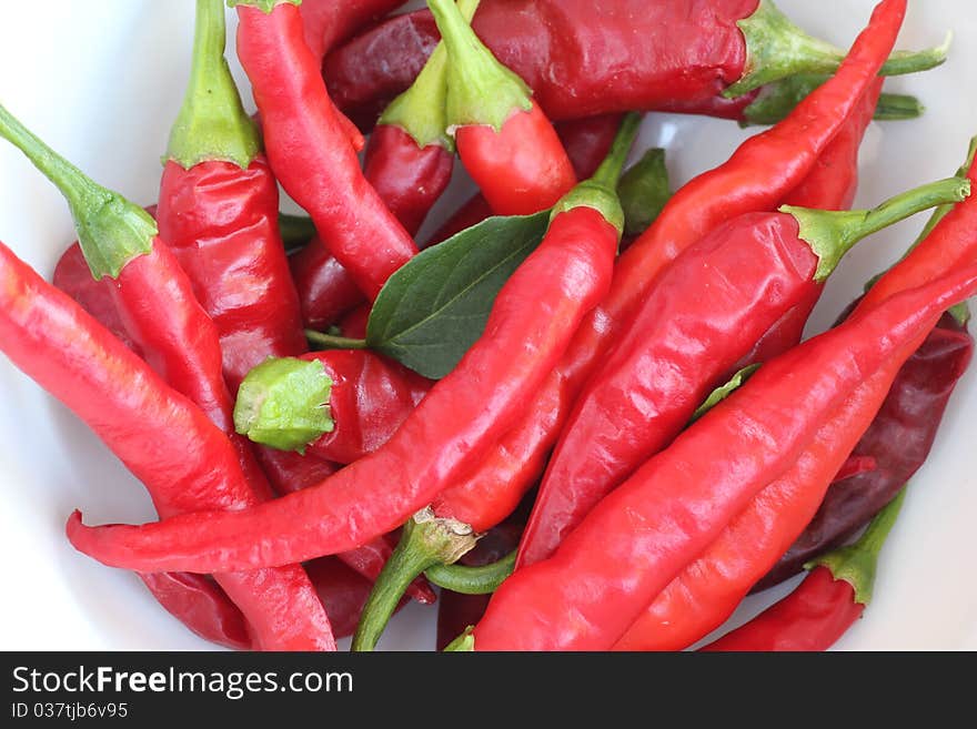 Close-up of red chili peppers piled in a white bowl. Close-up of red chili peppers piled in a white bowl