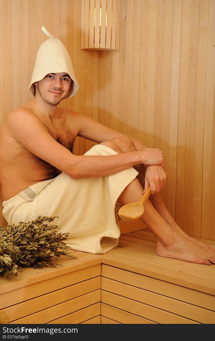 Young handsome man in a russian wooden sauna