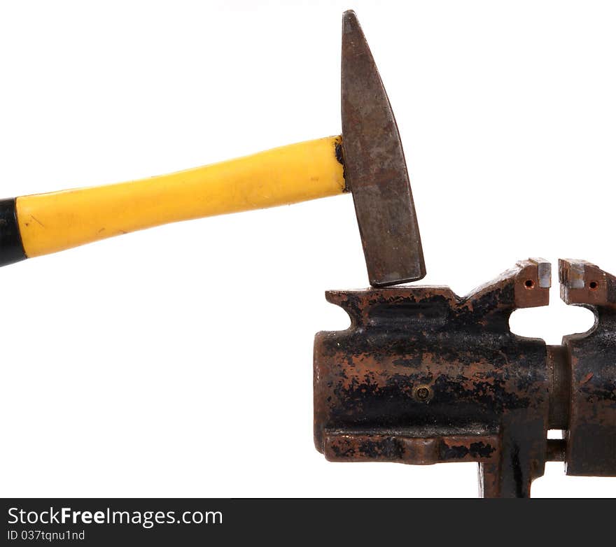 Rusty old bench vise and a hammer on a white background