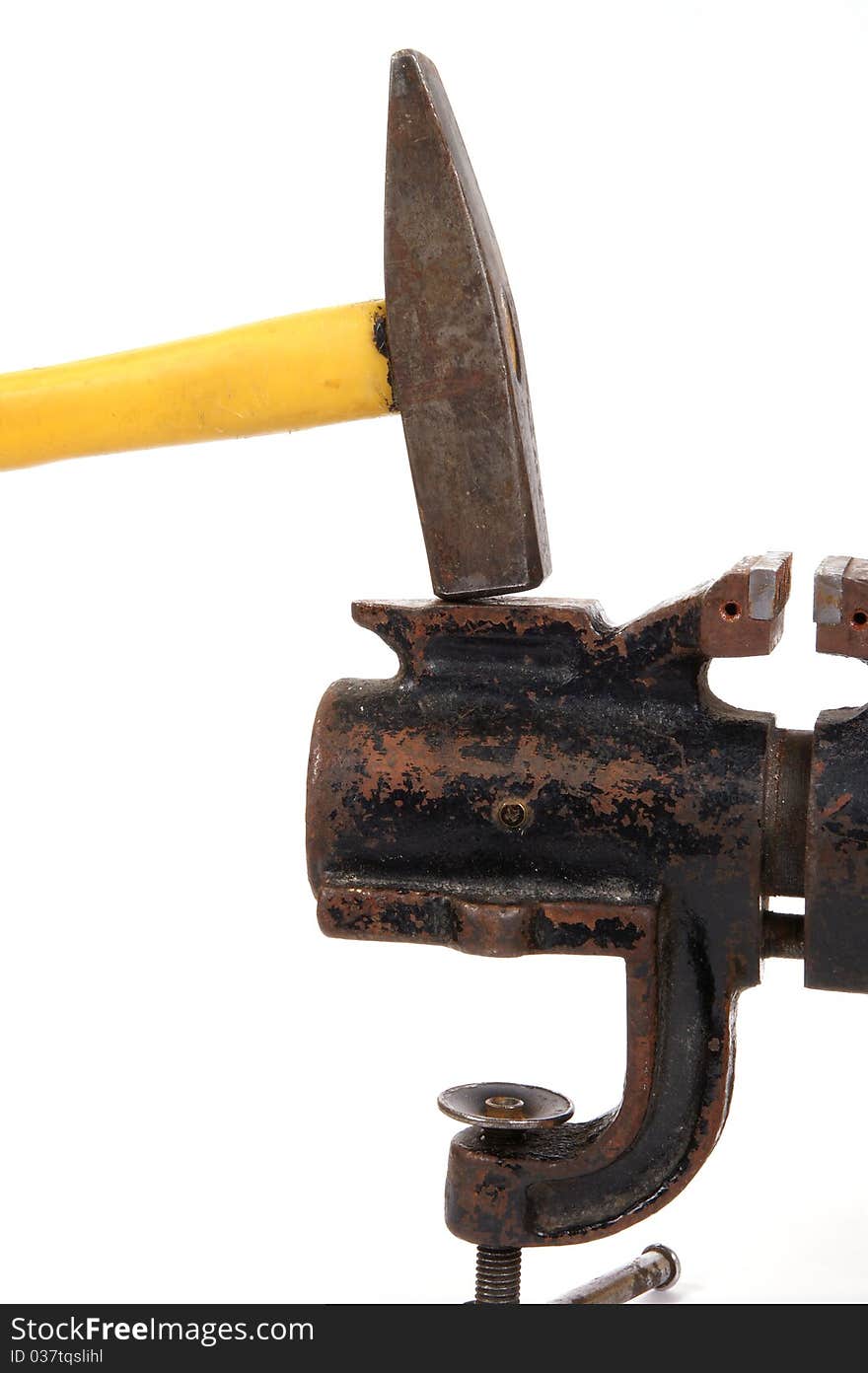 Rusty old bench vise and a hammer on a white background