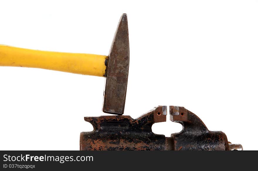 Rusty old bench vise and a hammer on a white background