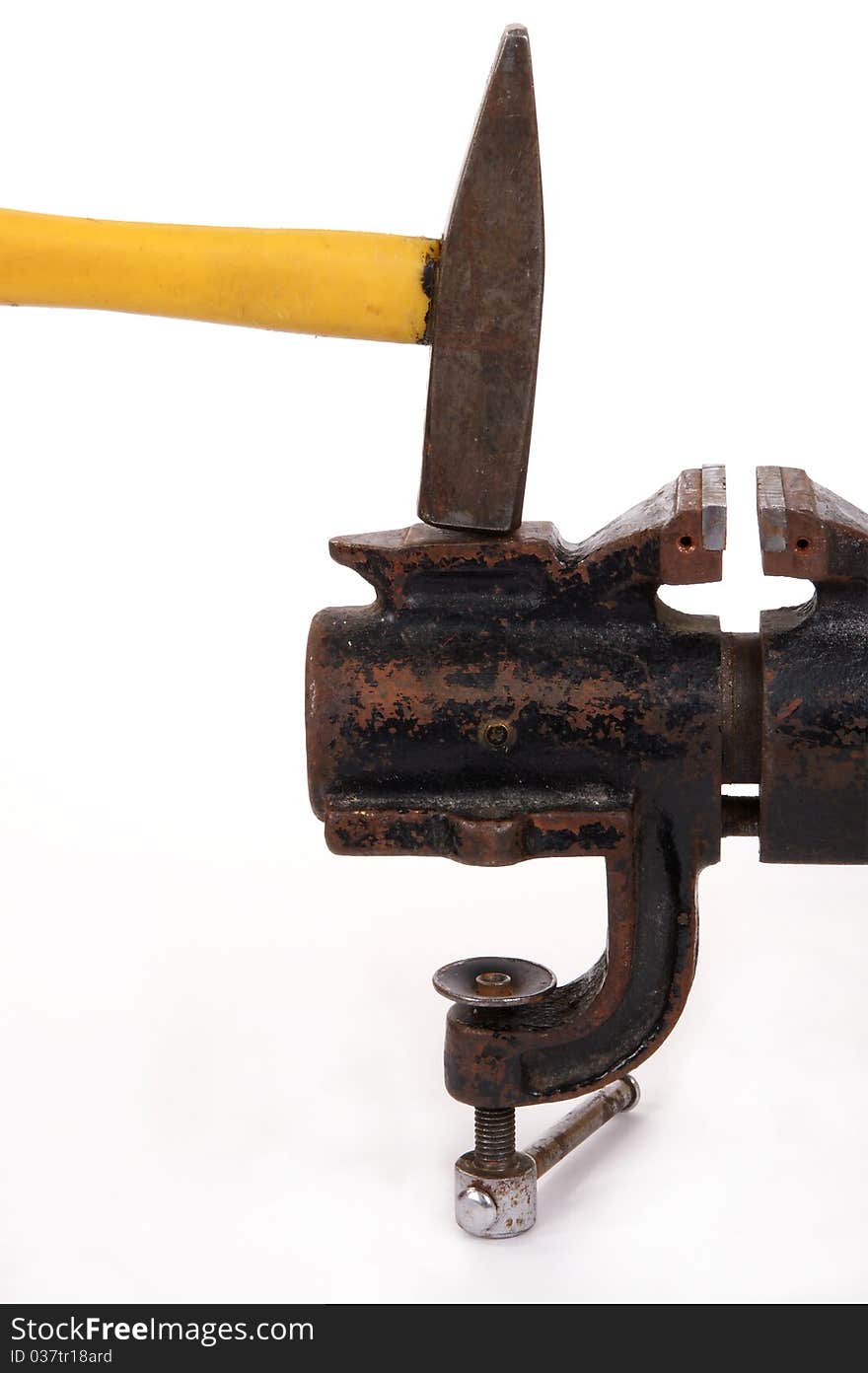 Rusty old bench vise and a hammer on a white background