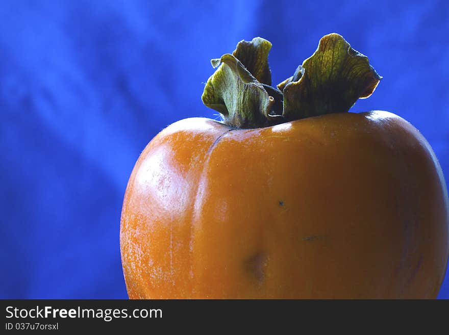 Persimmons isolated on blue background