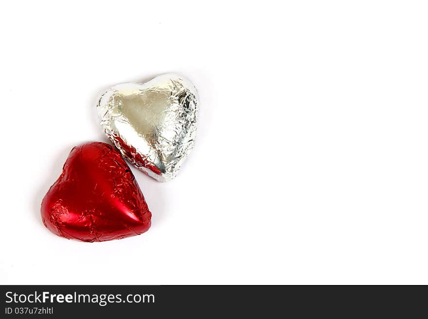 Red and silver chocolate hearts on a white background