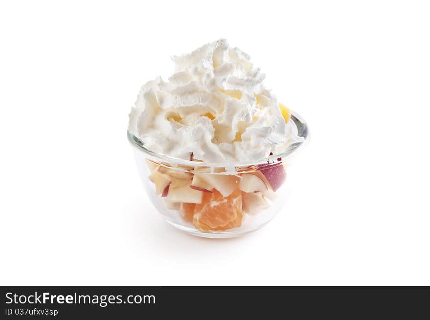 Fruit salad with whipped cream in the glass bowl isolated on white. Fruit salad with whipped cream in the glass bowl isolated on white